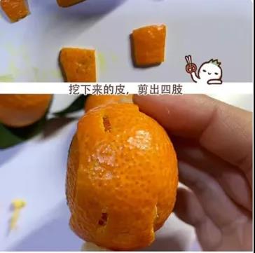 步骤3：在小的砂糖橘上画上冰墩墩的眼睛、鼻子和嘴巴；用挖下来的橘子皮剪出冰墩墩的四肢；